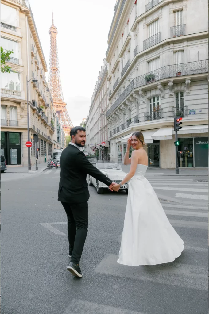 He led her across the empty crossing by the hand, she turned back over her shoulder to look at me, and the whole street seemed to hold still for a second. Golden light on pale stone, a quiet morning in the 7th, and two people who had already forgotten I was there. This is what I photograph couples in Paris for. Photographed by Julia Litvin, litvinphoto.com.